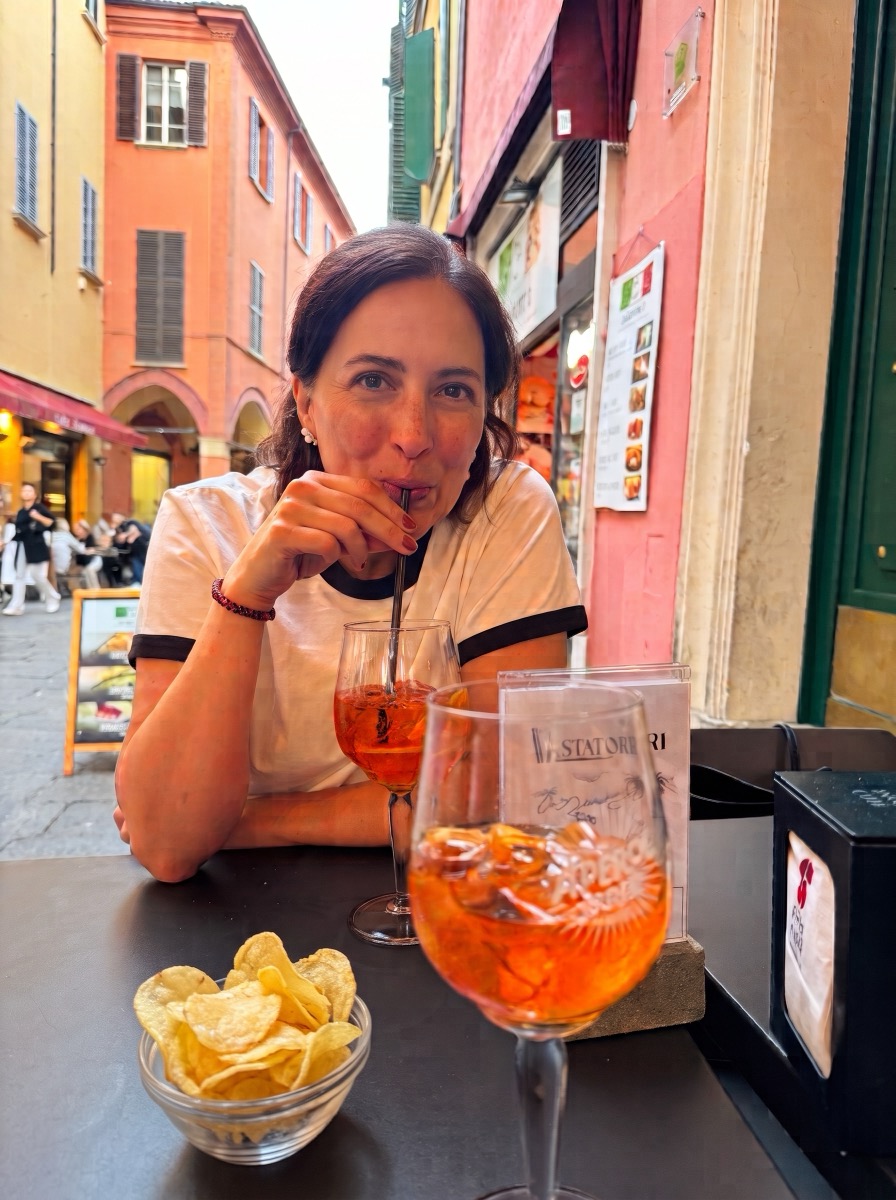 Ally with an Aperol Spritz and potato chips at the bar in Bologna